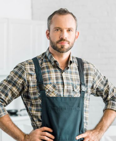 2-handsome-plumber-in-overalls-and-tool-belt-looking-BX3Q7UN.jpg